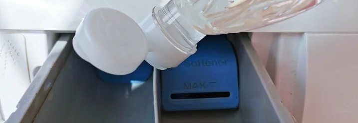 Weichspüler wird in eine Waschmaschine gefüllt